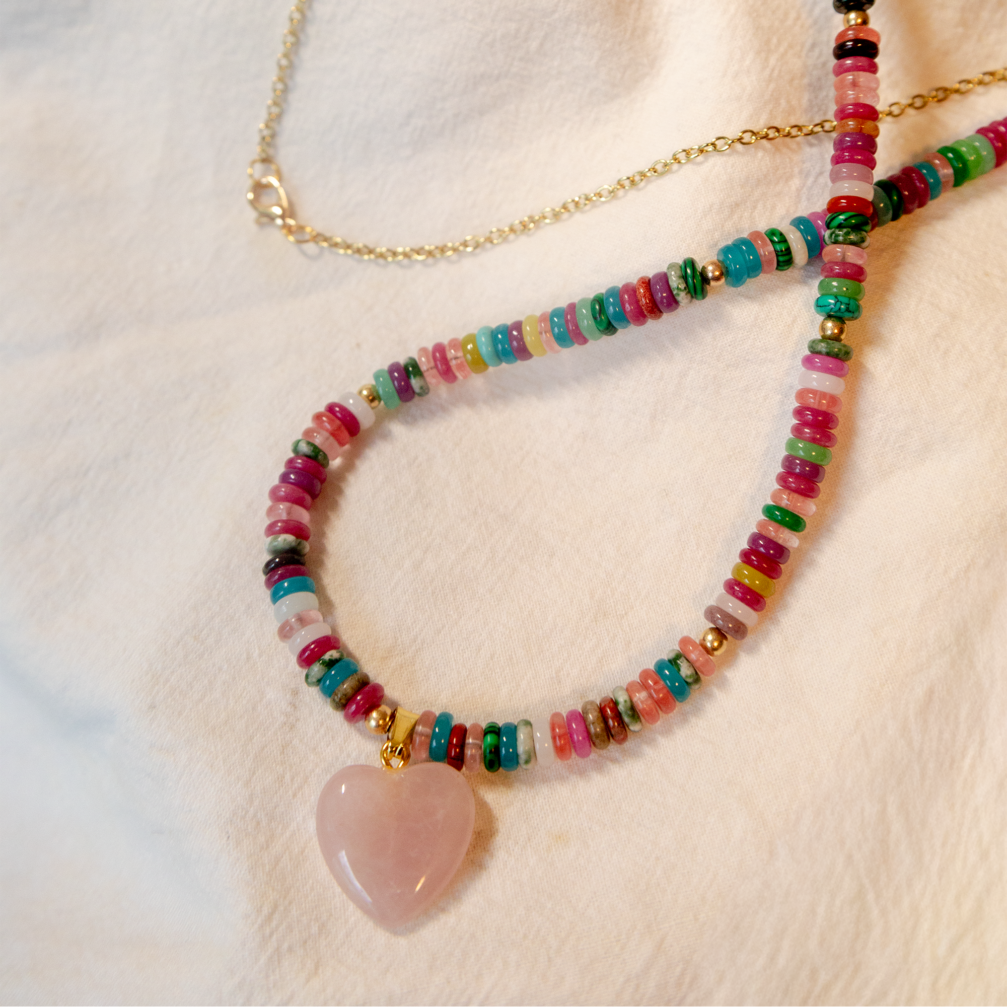 Colorful beaded necklace with a heart-shaped pendant on a light background