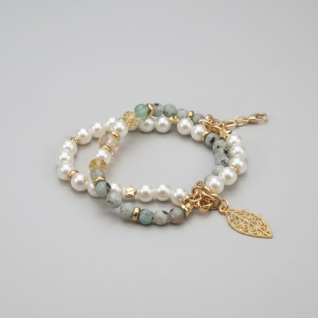 Pearl and gemstone bracelet with a gold leaf charm on a colorful background