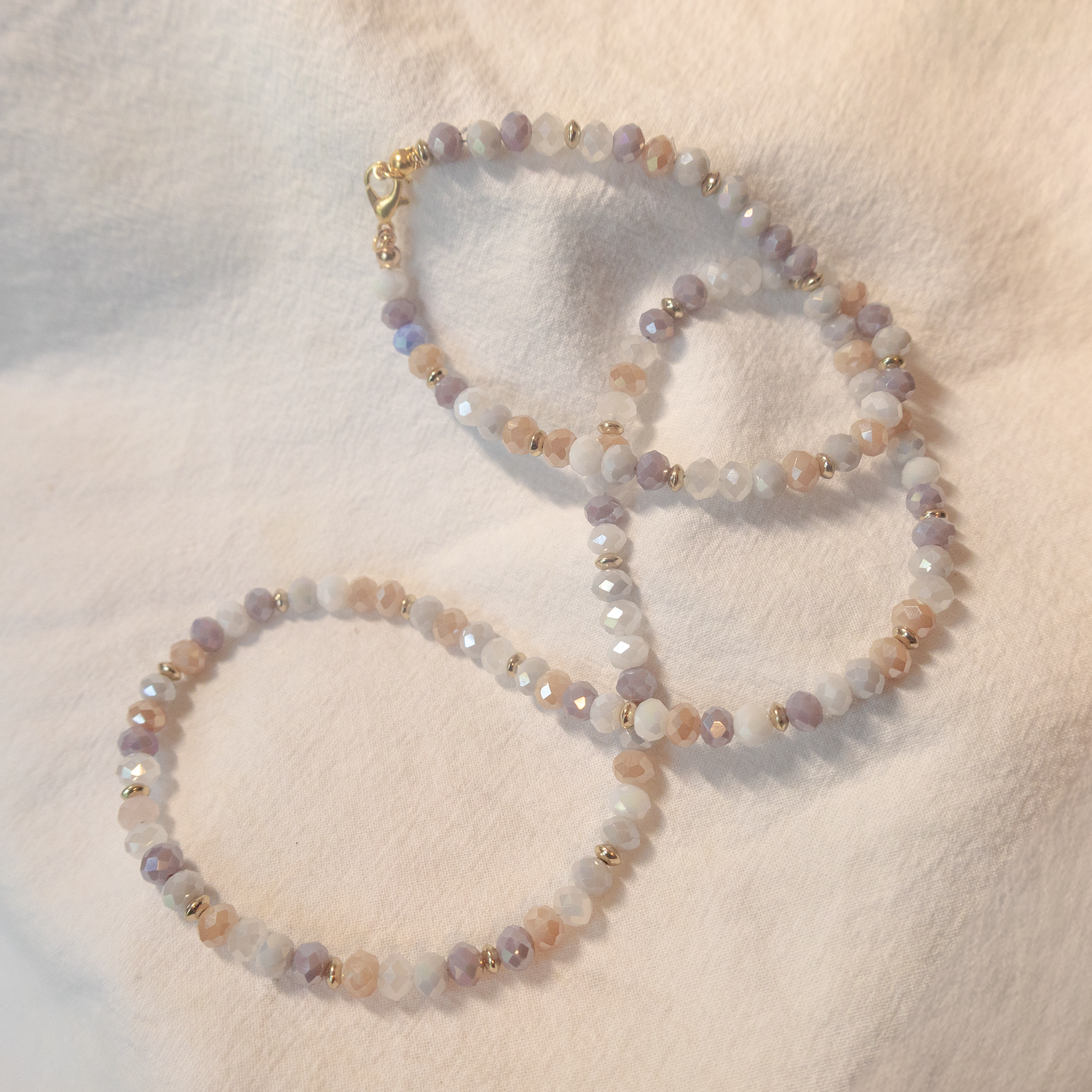 Two beaded bracelets on a soft white surface