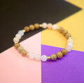 Beaded bracelet on a hand against a colorful geometric background