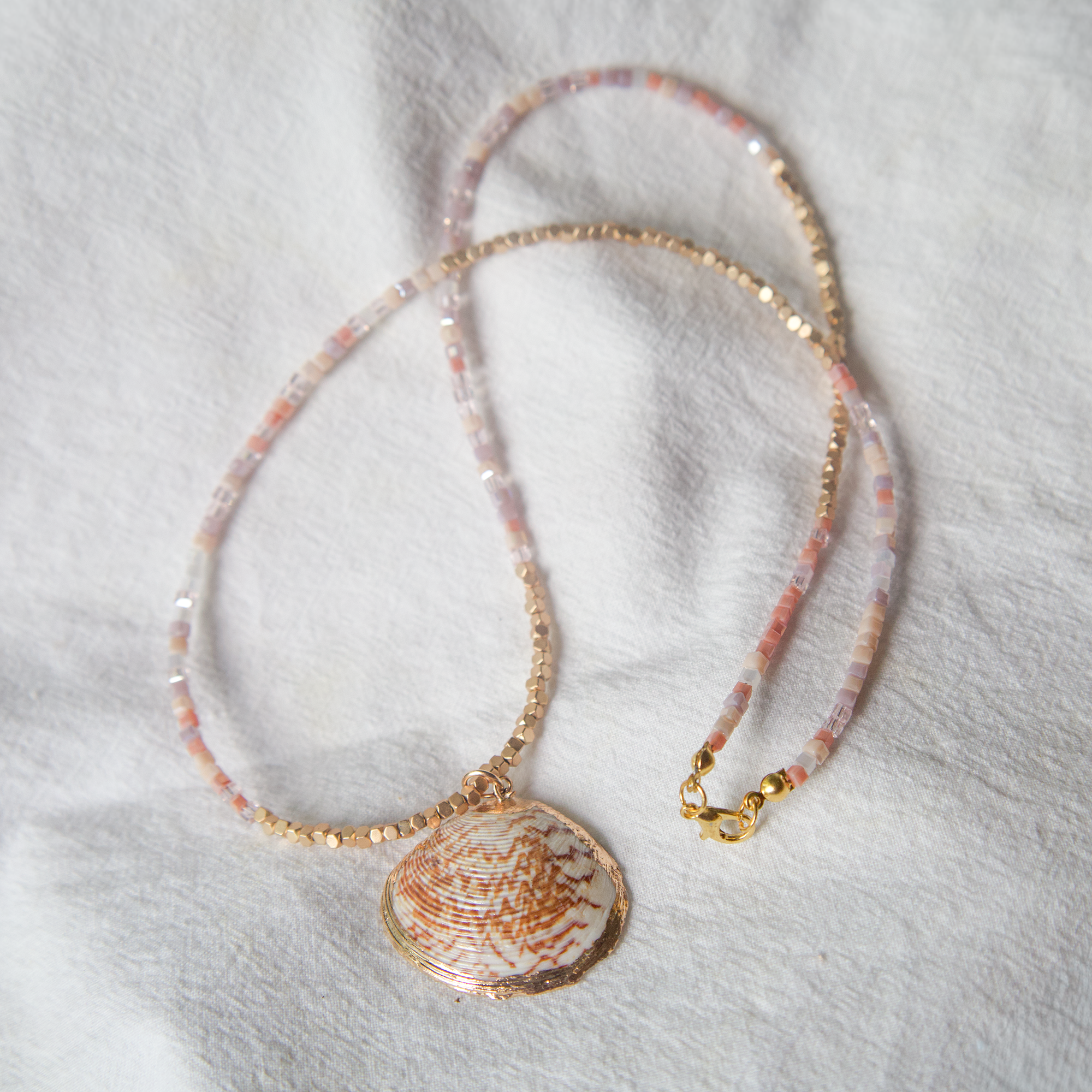 Necklace with a shell pendant on a white fabric background
