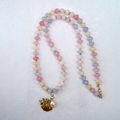 Beaded necklace with a gold charm on a white background